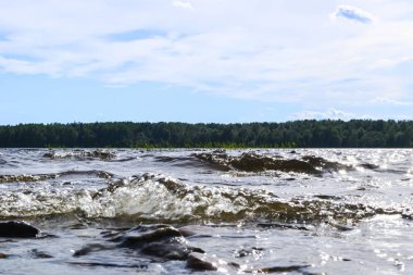 Büyük rüzgarlı dalgalar kayaların üzerine sıçramasına. Plaj karşı gölde dalga sıçrama. Bir sprey oluşturan dalgalar taşlı bir kumsalda kırma. Su sıçraması. Su yüzey dokusu