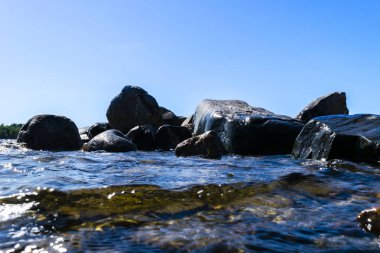 Büyük rüzgarlı dalgalar kayaların üzerine sıçramasına. Plaj karşı gölde dalga sıçrama. Bir sprey oluşturan dalgalar taşlı bir kumsalda kırma. Su sıçraması. Su yüzey dokusu