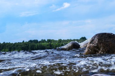 Büyük rüzgarlı dalgalar kayaların üzerine sıçramasına. Plaj karşı gölde dalga sıçrama. Bir sprey oluşturan dalgalar taşlı bir kumsalda kırma. Su sıçraması. Su yüzey dokusu