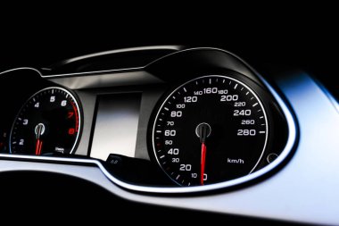 Arabadaki hız göstergesine yakın çekim. Araba konsolu. Gösterge paneli, lambalar, araba enstrüman paneli. Gösterge paneli hız göstergesi, takometre, kilometre sayacı. Araba tamiri. Modern iç mimari