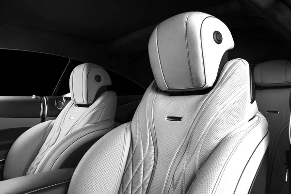 Modern Luxury car inside. Interior of prestige modern car. Comfortable leather seats. Perforated leather cockpit with isolated Black background. Modern car interior details. Black and white