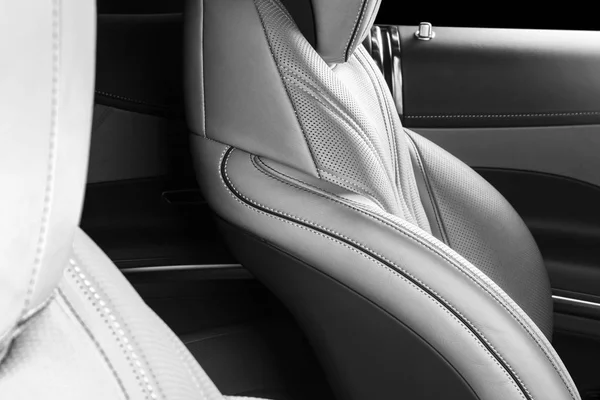AC Ventilation Deck in Luxury modern Car Interior. Modern car interior details with leather stitching. Carbon panel. Perforated leather steering wheel. Black and white