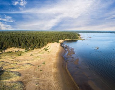 Sahili, lagünleri ve mercan resifleri olan deniz manzarası. Kum ve suyla kıyı şeridi. Tropik bir manzara. Hava fotoğrafçılığı. Kuş gözü. Deniz, sahil, gökyüzü, bulutlar.