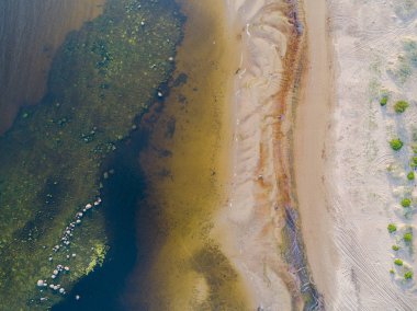 Sahili, lagünleri ve mercan resifleri olan deniz manzarası. Kum ve suyla kıyı şeridi. Tropik bir manzara. Hava fotoğrafçılığı. Kuş gözü. Deniz, sahil, gökyüzü, bulutlar.