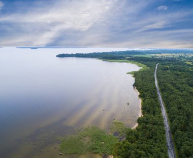 Havadan görünümü karayolu. Köy yolunda göl yakınındaki hava görünümünü. Tarafından geçen araba. Hava yolu. Uçan hava görünümünü. Yukarıdan bir dron ile ele geçirdi. Yumuşak aydınlatma