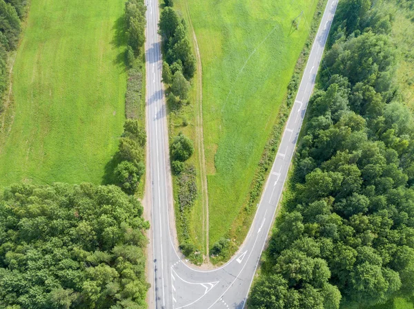 Aerial view of highway. Aerial view of a country road. Car passing by. Aerial road. Aerial view flying. Captured from above with a drone.