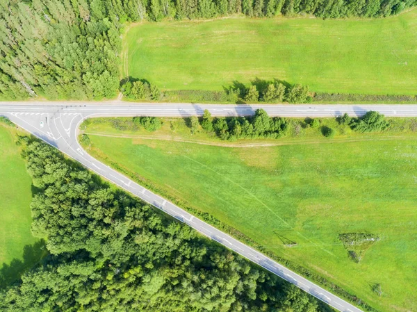 Aerial view of highway. Aerial view of a country road near the lake. Car passing by. Aerial road. Aerial view flying. Captured from above with a drone. Soft lighting