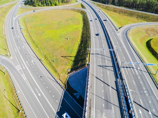 Aerial view of highway in city. Cars crossing interchange overpass. Highway interchange with traffic. Aerial bird\'s eye photo of highway. Expressway. Road junctions. Car passing. Top view from above.
