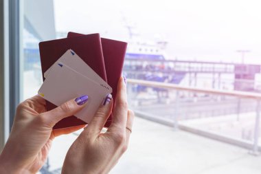 Pasaport tutarak ve yatılı güzel kadın el closeup geçmek bilet havaalanında terminal. Seyahat ve tatil kavramı. Terminal salonu. Boş alanı. Kopya alanı.