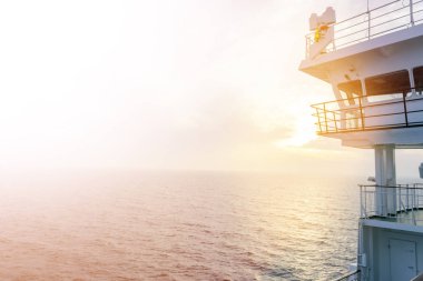 Cruise gemi beyaz kabin büyük pencereler ile. Çalışan köprü cruise liner kanat. Radar ve navigasyon sistemi ile mavi bir gökyüzü beyaz yolcu gemisinde. Tamam. Okyanusu günbatımı arka plan.