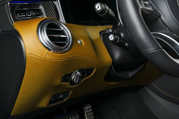 AC havalandırma güverte lüks modern araba iç. Modern araba turuncu dikiş ile turuncu ve siyah deri iç detaylarla. Karbon paneli. Delikli deri direksiyon simidi