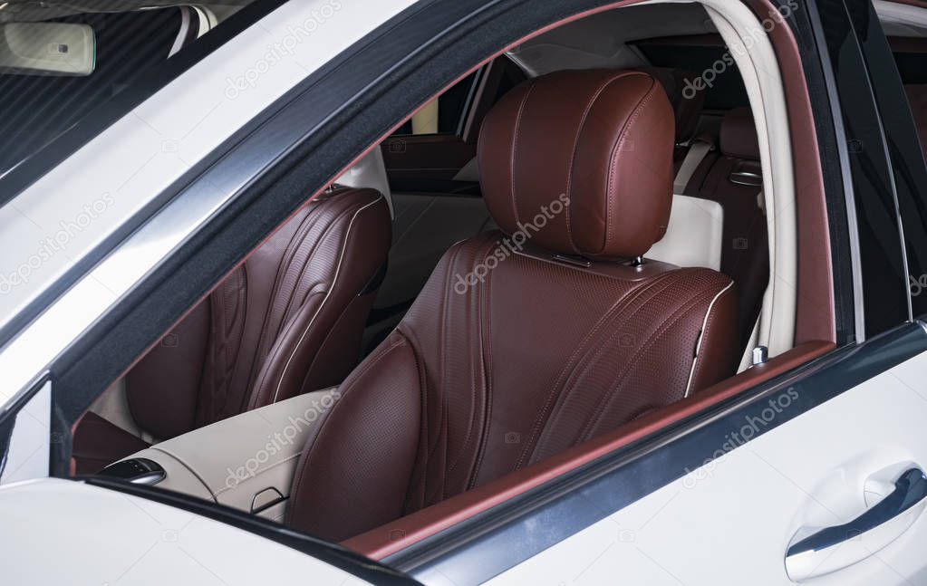 Modern Luxury car inside. Interior of prestige modern car. Comfortable leather red seats. Red perforated leather cockpit with isolated Black background. Modern car interior details