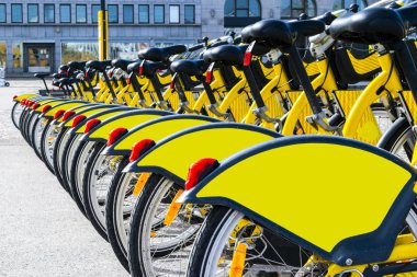 Satır Bisiklet Park. Satır Park edilmiş renkli bisiklet. Kiralama sarı bisikletler. Kiralık vintage Bisiklet Bisiklet üzerinde kaldırım desen. Tekerlek yakın çekim.