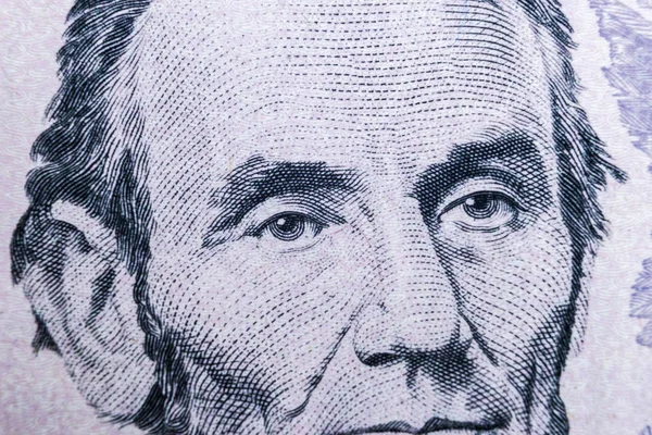 在五美元的钞票上 关闭查看亚伯拉罕 林肯的肖像 钱的背景 5美元钞票与亚伯拉罕 林肯眼睛宏观射击 钱的背景 — 图库照片