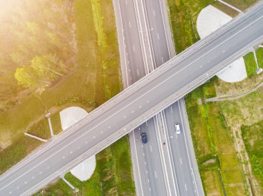 Şehirdeki otoyolun havadan görüntüsü. Arabalar üst geçitten geçiyor. Otoyol trafiği ile kesişir. Otobanın havadan çekilmiş kuş bakışı fotoğrafı. Çevre yolu. Yol ayrımları. Araba geçiyor. Yukarıdan üst görünüm. 