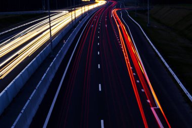 Otomobil hafif kavisli karayolu üzerinde geceleri yenik durumda. Gece trafik yollar. Hareket bulanıklığı. Gece şehir yol trafik Far hareket ile. Cityscape. Araç hareket bulanıklığı tarafından yol ışık.