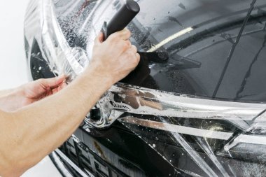 Araba kaydırma uzman vinil folyo ya da film araba koyarak. Koruyucu film. Koruyucu bir film çalışması için araçları ile uygulanıyor. Araba ayrıntılı. Şeffaf film. Araç boya koruma. Kırpma. 