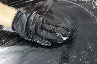 Mikrofiber bezle araba temizlik bir adam. Araba ayrıntılı. Kavram valeting. Seçici odak. Araba ayrıntılı. Süngerle Temizleme. Temizlik işçisi. Mikrofiber ve temizleme solüsyonu temizlemek için