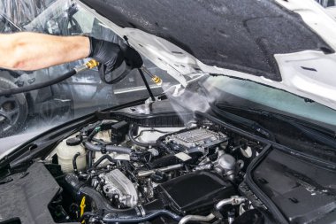 Araba ayrıntılı. Basınçlı su ile el ile araba yıkama motoru. Araba motoru su bașlığı ile yıkama. Araba washman çalışan temizlik otomobil. Basınç yıkama oto yıkama için püskürtme adam