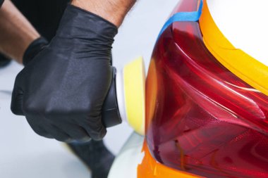 Parlatıcı ve Lehçe holding araba Lehçe balmumu işçisi eller. El araba Perdah dayanabiliyor kapatın. Adam elinde bir Parlatıcı tutar ve araba parlatır. Araba Detaylandırma