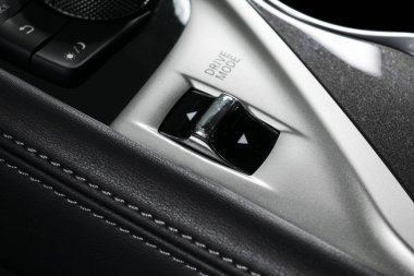 Parça kontrol düğmeleri yakınındaki dikişli siyah deri iç modern bir araba otomatik vites kolu. Araba iç ayrıntılar. Araba Detaylandırma