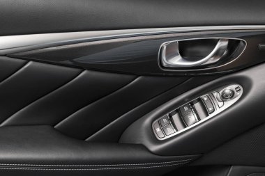 Kapı kolu güç pencere denetim düğmeleri bir lüks yolcu araba ile. Siyah deri iç lüks modern otomobil dikişli delikli. Modern araba iç ayrıntılar. Araba Detaylandırma.