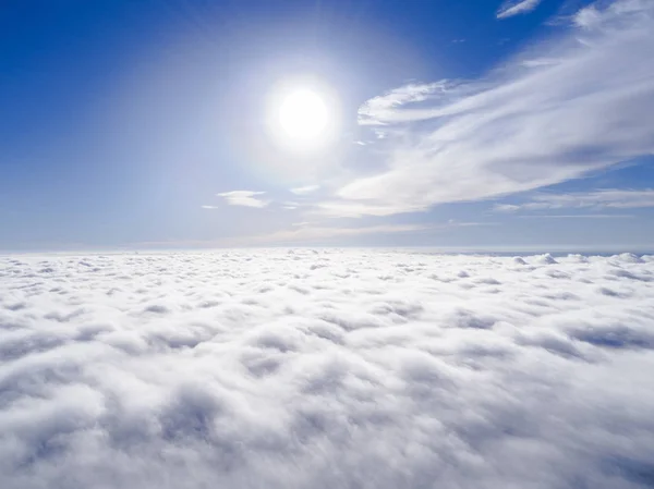 Aerial view White clouds in blue sky. Top view. View from drone. Aerial bird\'s eye view. Aerial top view cloudscape. Texture of clouds. View from above. Sunrise over clouds