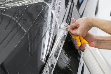 Araba kaydırma uzman vinil folyo ya da film araba koyarak. Koruyucu film. Koruyucu bir film çalışması için araçları ile uygulanıyor. Araba ayrıntılı. Şeffaf film. Araç boya koruma. Kırpma. 