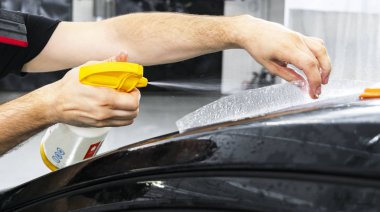 Araba kaydırma uzman vinil folyo ya da film araba koyarak. Koruyucu film. Koruyucu bir film çalışması için araçları ile uygulanıyor. Araba ayrıntılı. Şeffaf film. Araç boya koruma. Kırpma. 