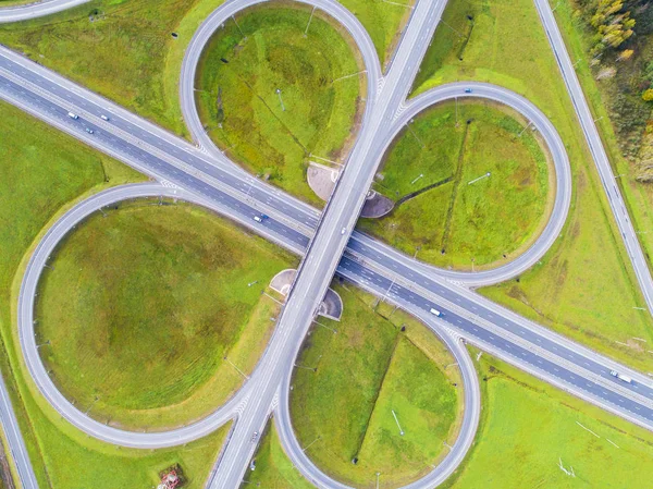 Şehirdeki otoyolun havadan görüntüsü. Arabalar üst geçitten geçiyor. Otoyol trafiği ile kesişir. Otobanın havadan çekilmiş kuş bakışı fotoğrafı. Çevre yolu. Yol ayrımları. Araba geçiyor. Yukarıdan üst görünüm.