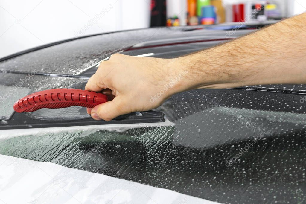 A man cleaning car with cloth. Car detailing concept. Selective focus. Car detailing. Cleaning with sponge. Worker cleaning. Cleaning solution to clean