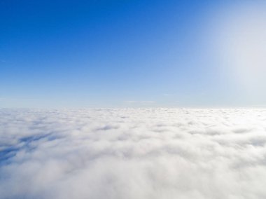 Mavi gökyüzünde havadan görünümü beyaz bulutlar. Üstten görünüm. Drone görüntüleyin. Hava kuş bakışı. Hava üstten görünüm cennet. Bulutlar doku. Yukarıdan görüntüleyin. Bulutlar üzerinde gündoğumu