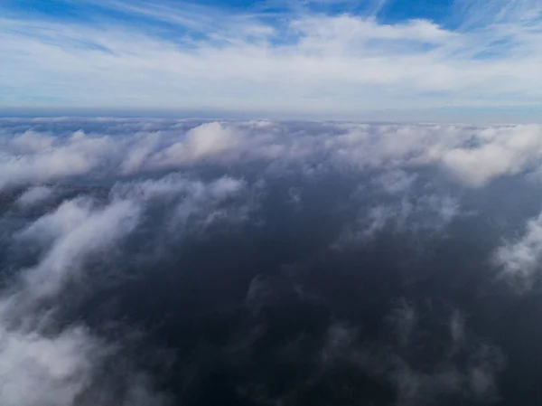 Aerial view White clouds in blue sky. Top view. View from drone. Aerial bird\'s eye view. Aerial top view cloudscape. Texture of clouds. View from above. Sunrise over the sea