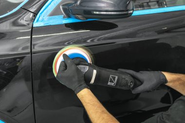Araba Lehçe balmumu işçisi uygulanan koruyucu bant parlatma önce eller. Polisaj ve parlatma araba. Araba ayrıntılı. Adam elinde bir Parlatıcı tutar ve araba parlatır