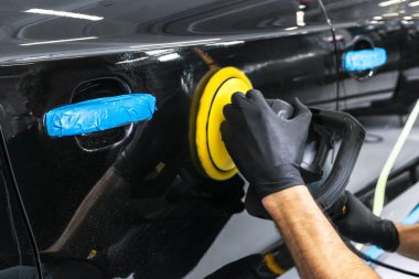 Araba Lehçe balmumu işçisi uygulanan koruyucu bant parlatma önce eller. Polisaj ve parlatma araba. Araba ayrıntılı. Adam elinde bir Parlatıcı tutar ve araba parlatır