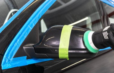 Araba Lehçe balmumu işçisi uygulanan koruyucu bant parlatma önce eller. Polisaj ve parlatma araba. Araba ayrıntılı. Adam elinde bir Parlatıcı tutar ve araba parlatır
