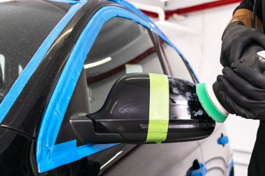 Araba Lehçe balmumu işçisi uygulanan koruyucu bant parlatma önce eller. Polisaj ve parlatma araba. Araba ayrıntılı. Adam elinde bir Parlatıcı tutar ve araba parlatır