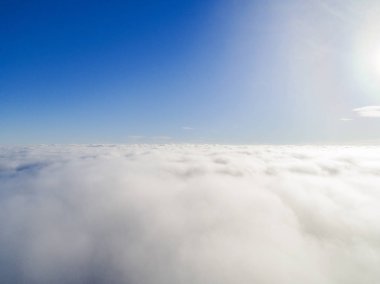 Mavi gökyüzünde havadan görünümü beyaz bulutlar. Üstten görünüm. Drone görüntüleyin. Hava kuş bakışı. Hava üstten görünüm cennet. Bulutlar doku. Yukarıdan görüntüleyin. Bulutlar üzerinde gündoğumu