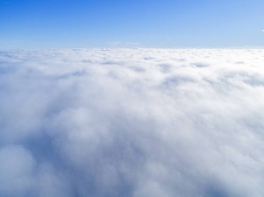 Mavi gökyüzünde havadan görünümü beyaz bulutlar. Üstten görünüm. Drone görüntüleyin. Hava kuş bakışı. Hava üstten görünüm cennet. Bulutlar doku. Yukarıdan görüntüleyin. Bulutlar üzerinde gündoğumu