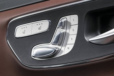 Kapı kolu güç koltuk kontrol düğmeleri bir lüks yolcu araba ile. Kahverengi deri iç lüks modern araba beyaz dikişli. Modern araba iç ayrıntılar. Araba Detaylandırma