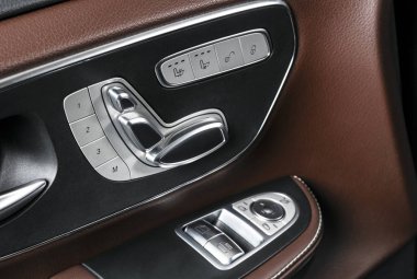 Kapı kolu güç koltuk kontrol düğmeleri bir lüks yolcu araba ile. Kahverengi deri iç lüks modern araba beyaz dikişli. Modern araba iç ayrıntılar. Araba Detaylandırma