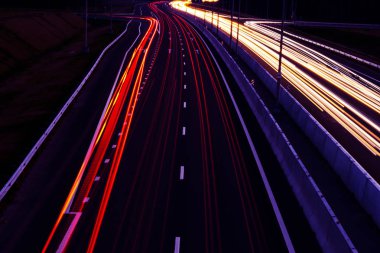 Otomobil hafif kavisli karayolu üzerinde geceleri yenik durumda. Gece trafik yollar. Hareket bulanıklığı. Gece şehir yol trafik Far hareket ile. Cityscape. Araç hareket bulanıklığı tarafından yol ışık.