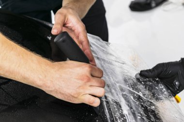 Araba kaydırma uzman vinil folyo ya da film araba koyarak. Koruyucu film araba. Koruyucu bir film çalışması için araçları ile araba uygulamak. Araba ayrıntılı. Şeffaf film. Araç boya koruma. Kırpma.