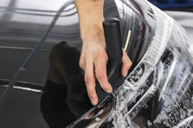 Araba kaydırma uzman vinil folyo ya da film araba koyarak. Koruyucu film araba. Koruyucu bir film çalışması için araçları ile araba uygulamak. Araba ayrıntılı. Şeffaf film. Araç boya koruma. Kırpma.