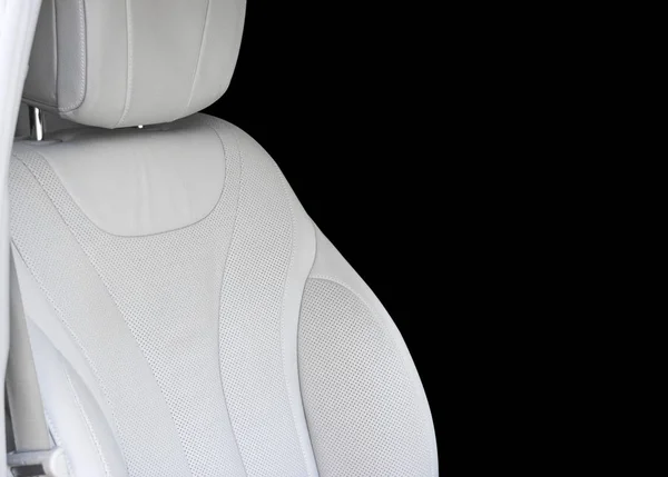 White leather interior of the luxury modern car. Leather comfortable white seats with stitching isolated on black background. Modern car interior details. Car detailing. Car inside