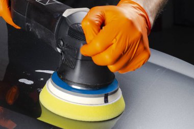 Araba Lehçe balmumu işçisi uygulanan koruyucu bant parlatma önce eller. Polisaj ve parlatma araba. Araba ayrıntılı. Adam elinde bir Parlatıcı tutar ve araba parlatır. Parlatma için Araçlar