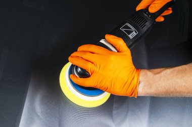 Araba Lehçe balmumu işçisi uygulanan koruyucu bant parlatma önce eller. Polisaj ve parlatma araba. Araba ayrıntılı. Adam elinde bir Parlatıcı tutar ve araba parlatır. Parlatma için Araçlar
