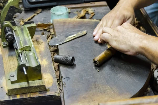 烟草厂的传统雪茄制造 在传统的雪茄制造中 用烟叶制作雪茄的老手的特写镜头 用烟叶做雪茄的双手合拢 — 图库照片