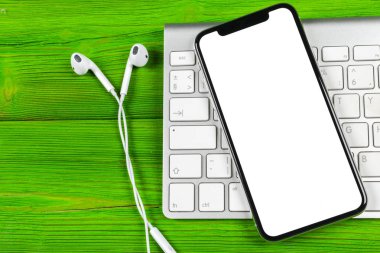 Smartphone ile boş perde kadar sahte. Smartphone izole ekran. Bilgisayar klavye üzerinde kopya alanı ile cep telefonu beyaz ekran. Metin için boş yer. İzole beyaz ekran