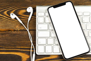 Smartphone ile boş perde kadar sahte. Smartphone izole ekran. Bilgisayar klavye üzerinde kopya alanı ile cep telefonu beyaz ekran. Metin için boş yer. İzole beyaz ekran